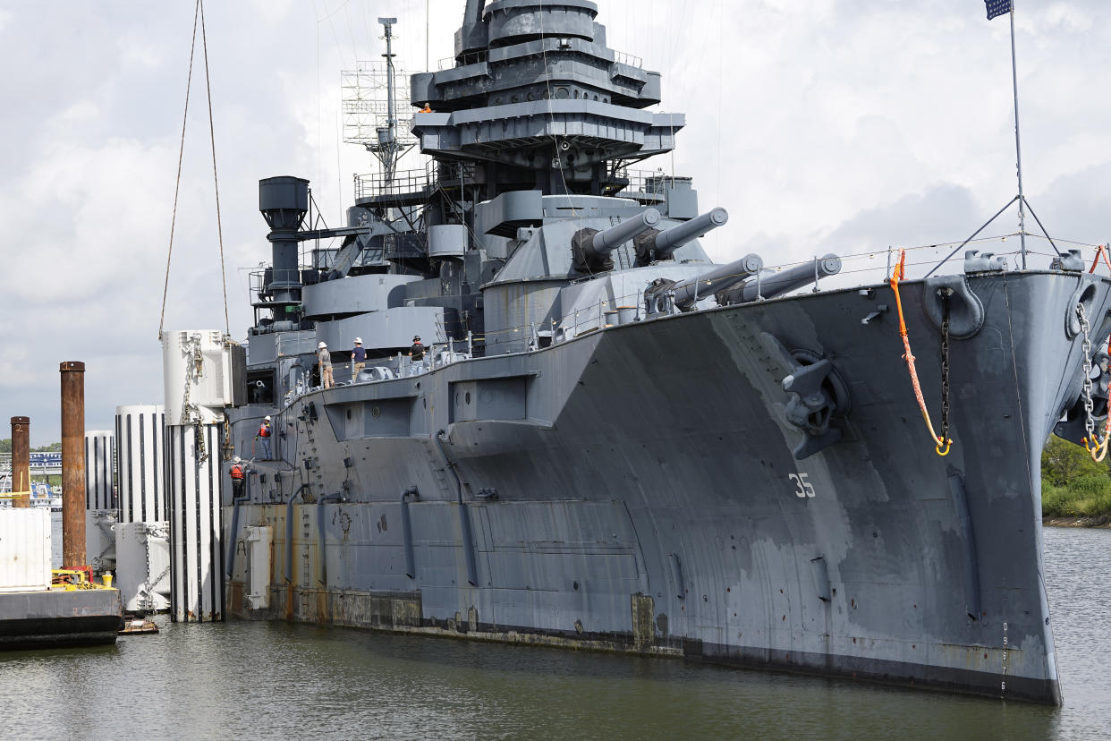 Preparations for moving the USS Texas continue Tuesday, Aug. 30, 2022, in La Porte, Texas. The vessel, which was commissioned in 1914 and served in both World War I and World War II, is scheduled to be towed down the Houston Ship Channel Wednesday to a dry dock in Galveston where it will undergo an extensive $35 million repair. (AP Photo/David J. Phillip)