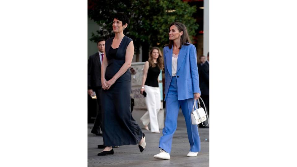 Queen Letizia of Spain in blue suit and Elma Saiz Delgado walking