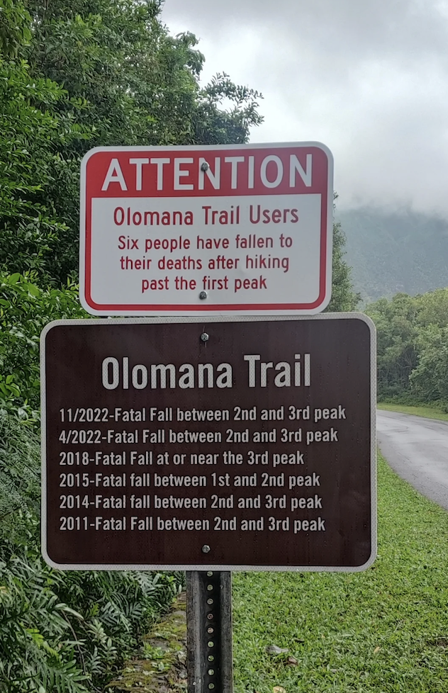 Sign stating, "Attention Olomana Trail Users: Six people have fallen to their deaths after hiking past the first peak." Below are specific fall incidents from 2011 to 2022