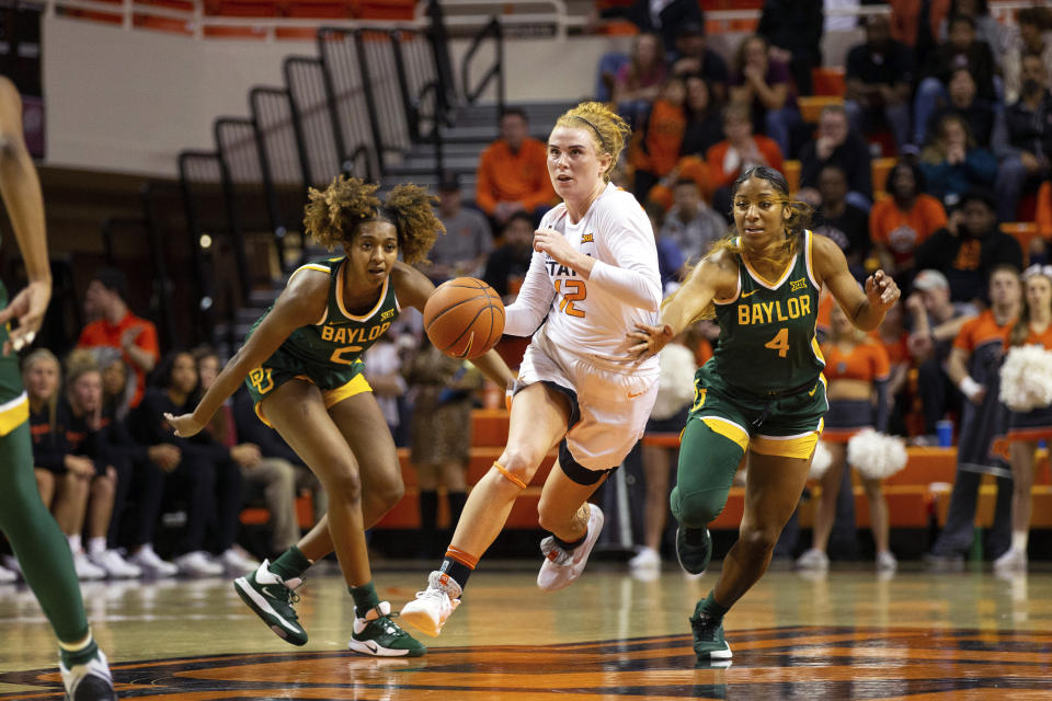 Oklahoma State forward Vivian Gray (12) drives the ball past Baylor guard DiDi Richards (2) and Baylor guard Te'a Cooper (4) during the first half of an NCAA college basketball game in Stillwater, Okla., Saturday, Feb. 15, 2020. (AP Photo/Brody Schmidt)