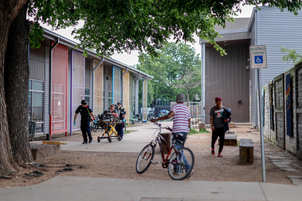 Paramedics roll a stretcher to their ambulance Friday outside the Homeless Alliance's Westtown Homeless Resource Campus in Oklahoma City.