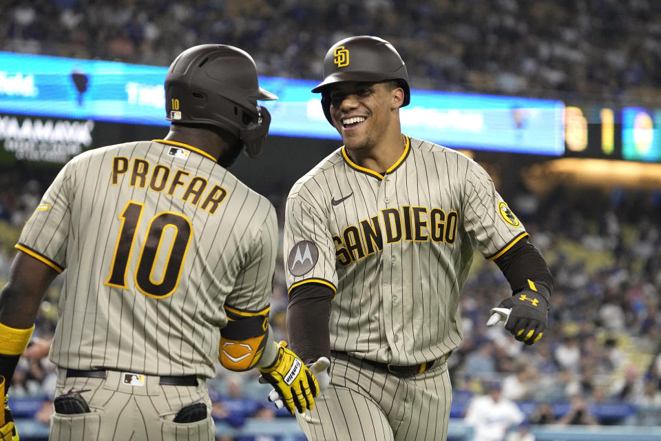 San Diego Padres' Juan Soto, right, celebrates with Jurickson Profar after hitting a solo home run during the first inning of a baseball game against the Los Angeles Dodgers Wednesday, Sept. 13, 2023, in Los Angeles. (AP Photo/Mark J. Terrill)