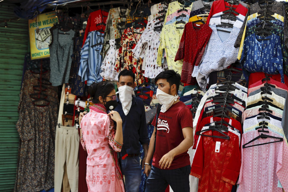 A woman shops for clothes at the Janpath market in New Delhi, India, Monday, June 1, 2020. More states opened up and crowds of commuters trickled onto the roads in many of India's cities on Monday as a three-phase plan to lift the nationwide coronavirus lockdown started despite an upward trend in new infections. (AP Photo/Manish Swarup)
