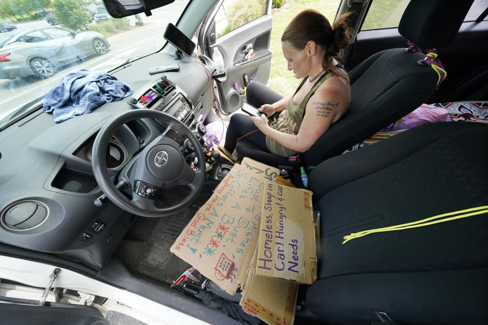 Miranda Atnip sits in her car in a parking lot on May 10, 2022, in Cookeville, Tenn. Atnip lost her home during the coronavirus pandemic and fell behind on bills. She now lives in her car and worries about getting money for food, finding somewhere to shower, and saving up enough money for an apartment where her three children can live with her again. Now she has a new worry: Tennessee is about to become the first U.S. state to make it a felony to camp on local public property such as parks. (AP Photo/Mark Humphrey)