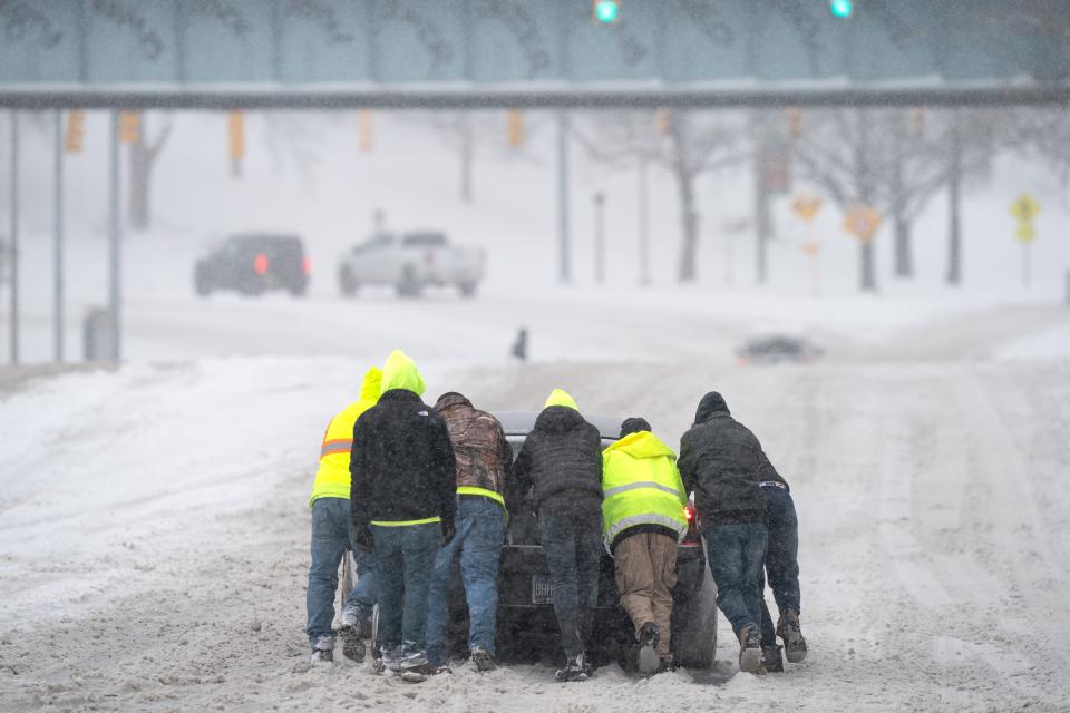 People help a driver out after his rear-wheel drive vehicle got stranded on Rosa L. Parks Blvd. after a winter storm in Nashville, Tenn., on Jan. 15, 2024.