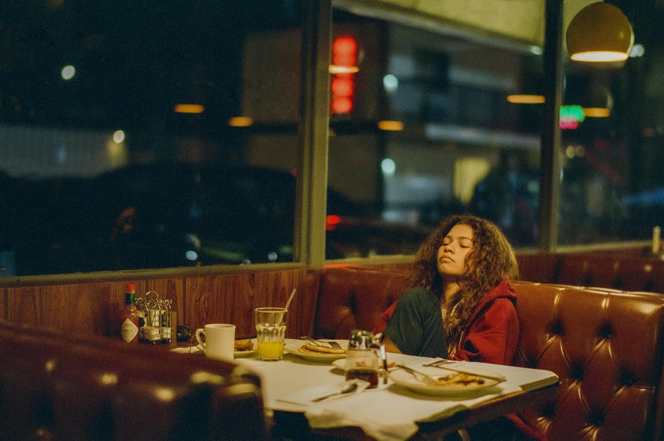 A still from &quot;Euphoria&quot; where Rue is resting with her eyes closed in a diner booth