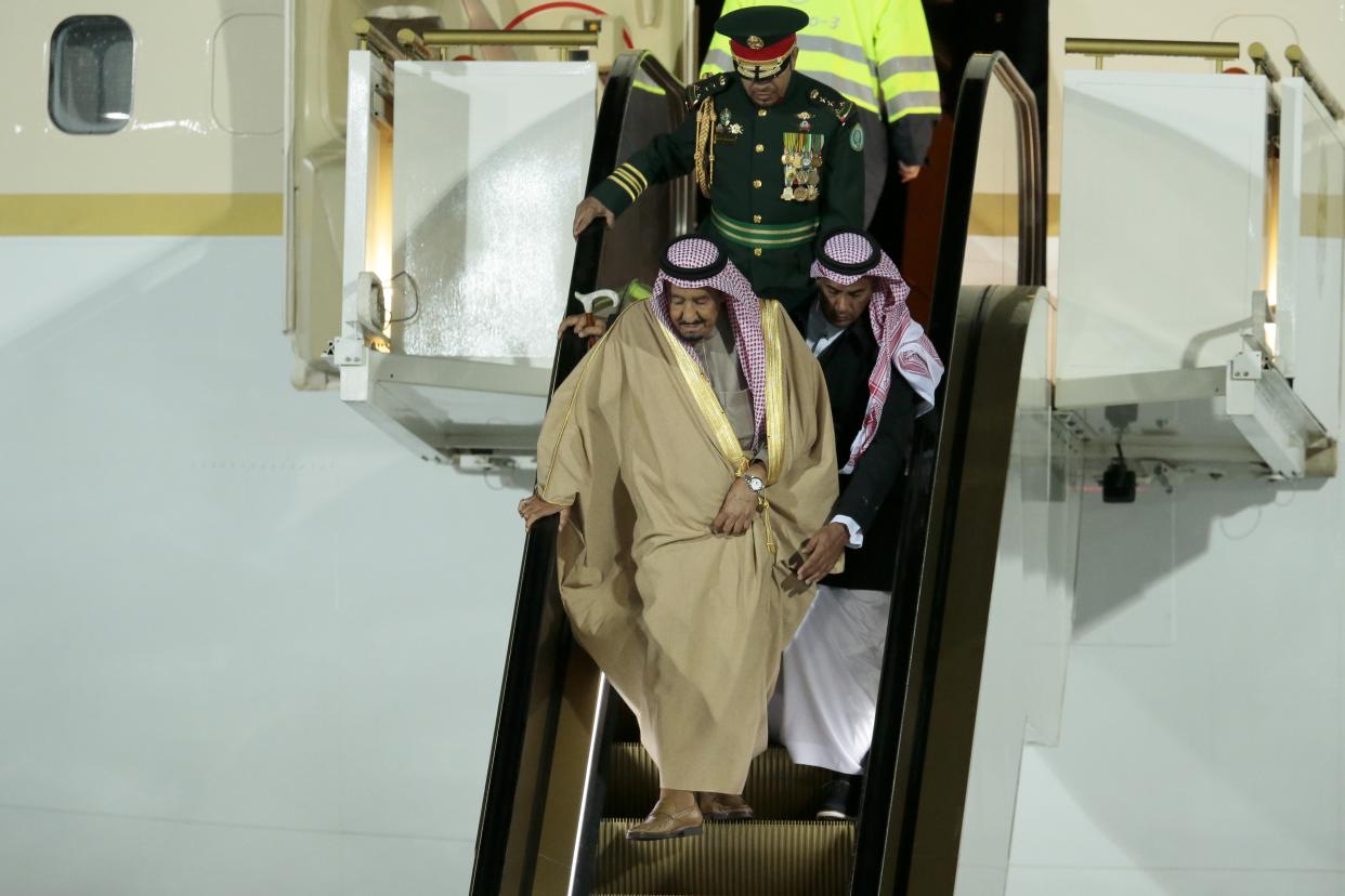 Making his own way down: Saudi King Salman was forced to walk down the steps of his gold escalator (AP Photo/Ivan Sekretarev)