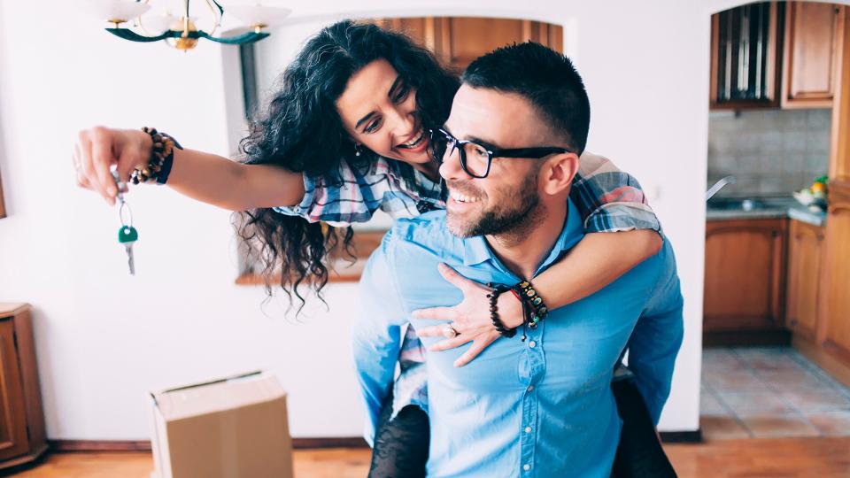 Young couple holding the keys for their new home