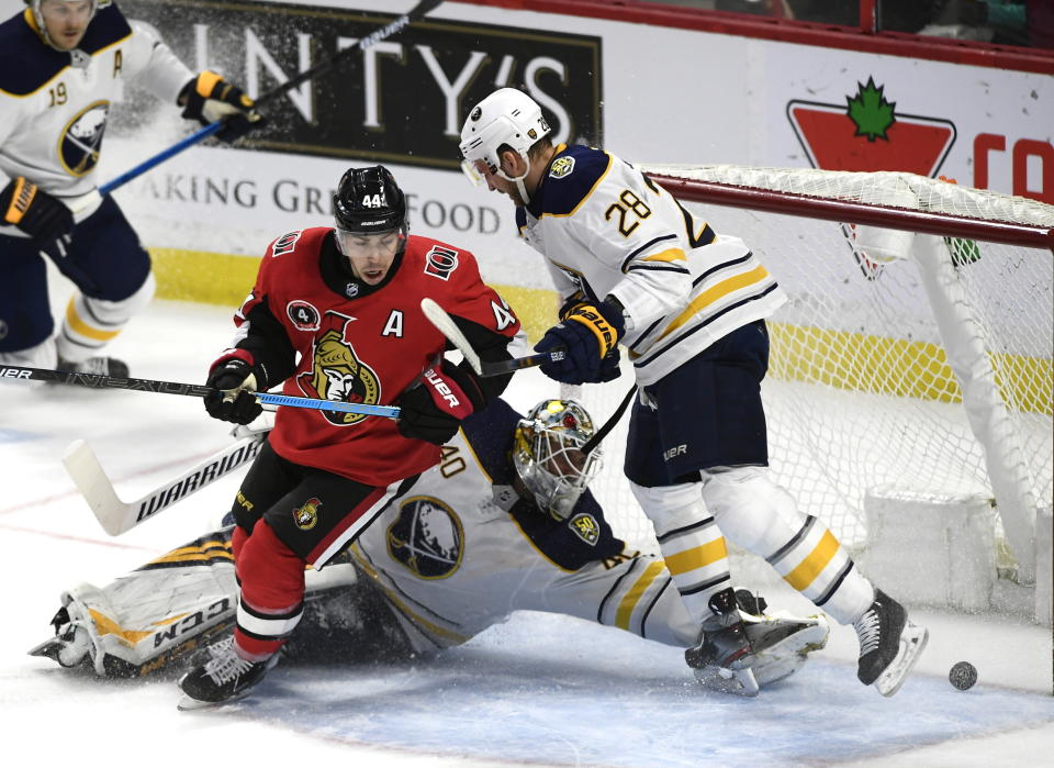 Ottawa Senators center Jean-Gabriel Pageau (44) turns to skate out of the crease as the puck crosses the goal line in front of Buffalo Sabres goaltender Carter Hutton (40) and center Zemgus Girgensons (28) during the second period of an NHL hockey game, Tuesday, Feb. 18, 2020 in Ottawa, Ontario. (Justin Tang/the Canadian Press via AP)