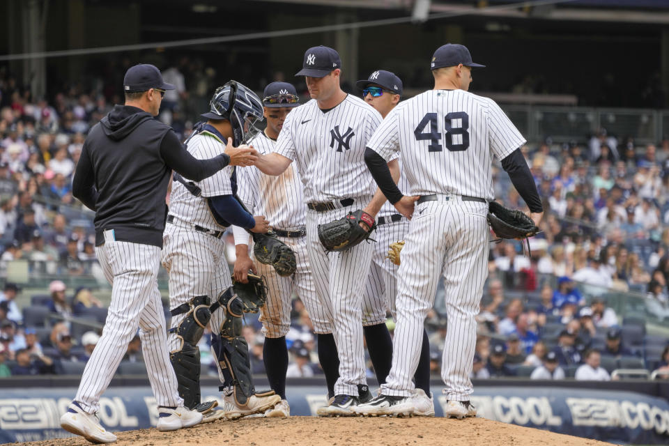 New York Yankees manager Aaron Boone, left, removes pitcher Gerrit Cole, center, in the sixth inning of a baseball game against the Toronto Blue Jays, Saturday, April 22, 2023, in New York. (AP Photo/Mary Altaffer)
