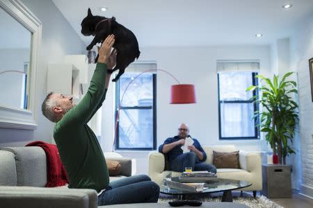 LGBT activist Daniel Maury relaxes at home with his partner, Mark Paulson, and dog Luca in New York April 13, 2015. REUTERS/Lucas Jackson