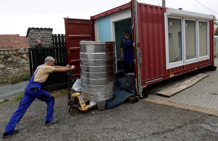 Workers of Smart Brewery Well Service move a brew kattle into a standard shipping container in the village of Chlum near the town of Trebic, Czech Republic, September 2, 2017. Picture taken September 2, 2017. REUTERS/David W Cerny