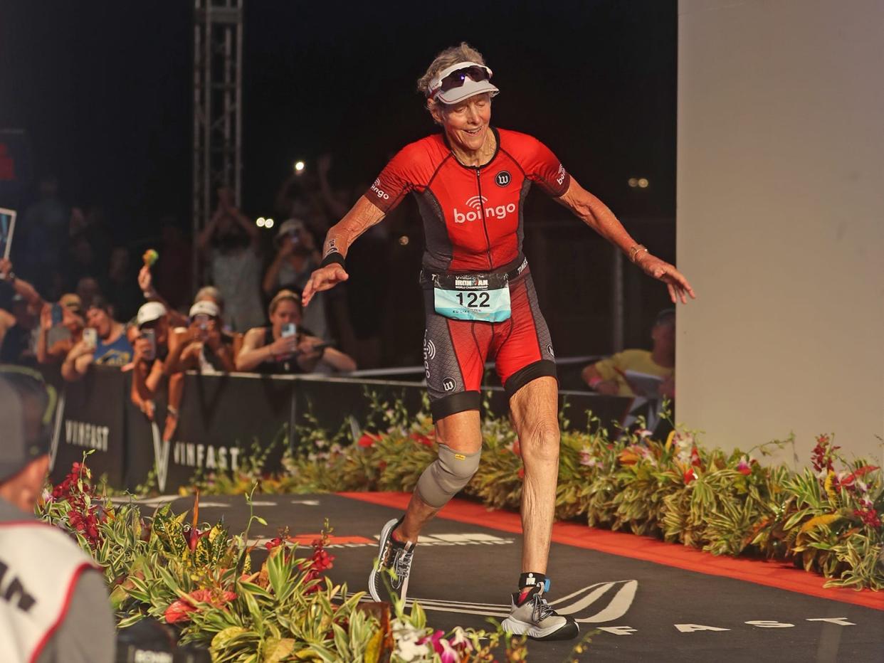 Cherie Gruenfeld crossing the finish line at an Ironman Triathlon.