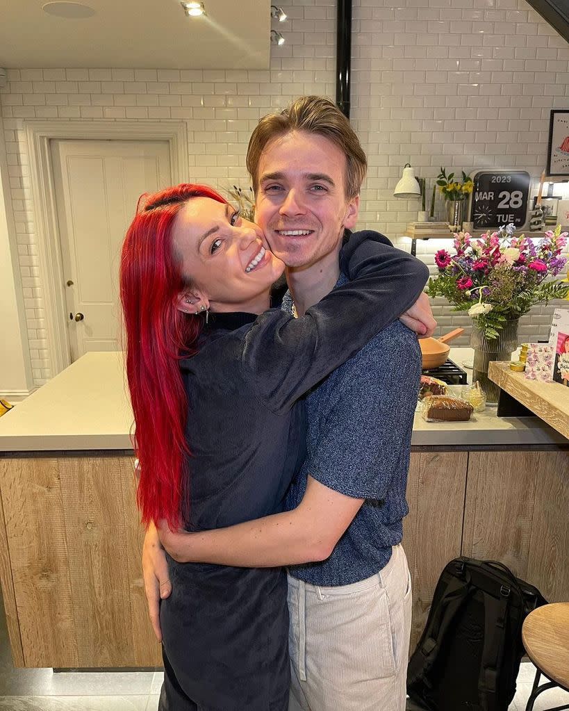 Dianne Buswell cradles her boyfriend Joe Sugg in their kitchen