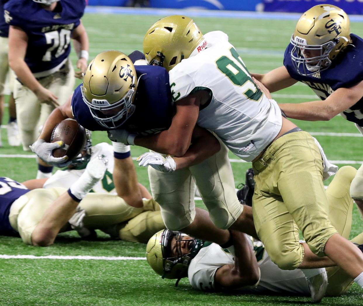 Jackson Lumen Christi's Kadale Williams tries to get into the end zone as Traverse City St. Francis' Conor Smith stops him during the first half of Lumen Christi's 15-12 win in the Division 7 state final at Ford Field on Saturday, Nov 26, 2022.