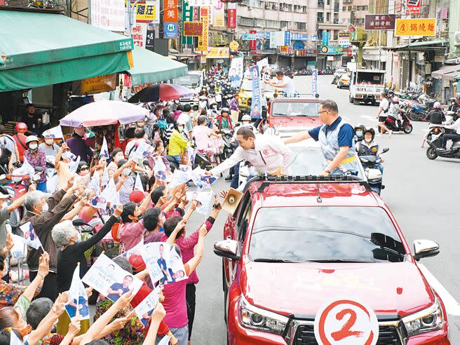 新北市長侯友宜（前排左）陪同議員候選人在三重車隊掃街拜票。（黃敬文攝）