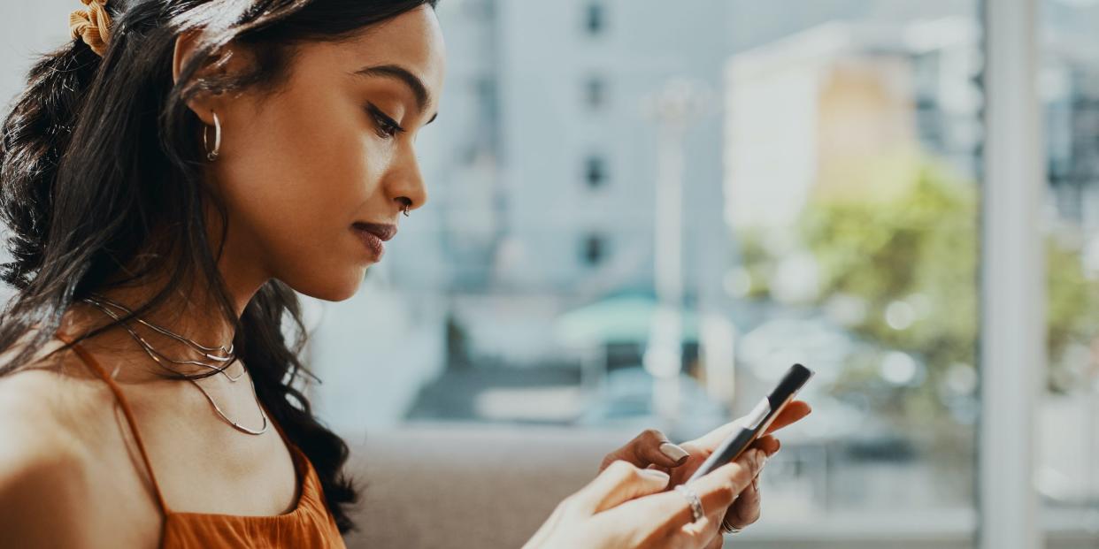 woman looking at phone texting at home