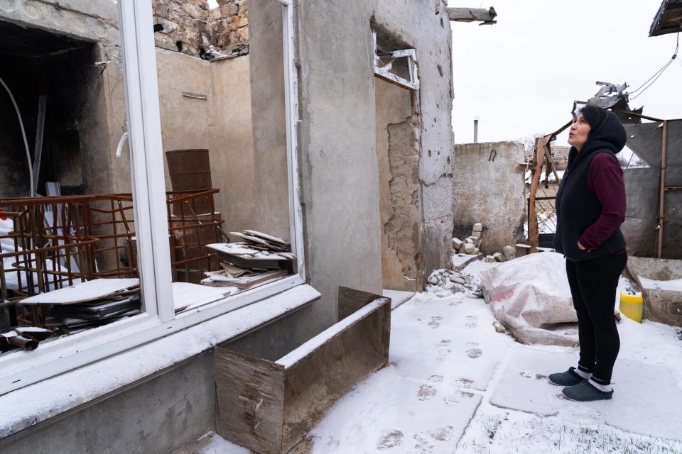 Olena Kovalyk surveys the damage to her family farm in the Kherson region of Ukraine.