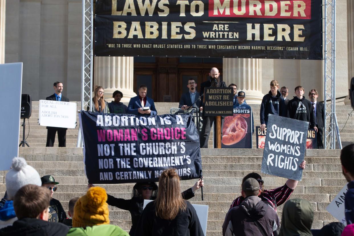 Anti-abortion protesters with AIM Kansas and abortion rights counter-protesters with The Satanic Grotto face off outside the Statehouse last month.