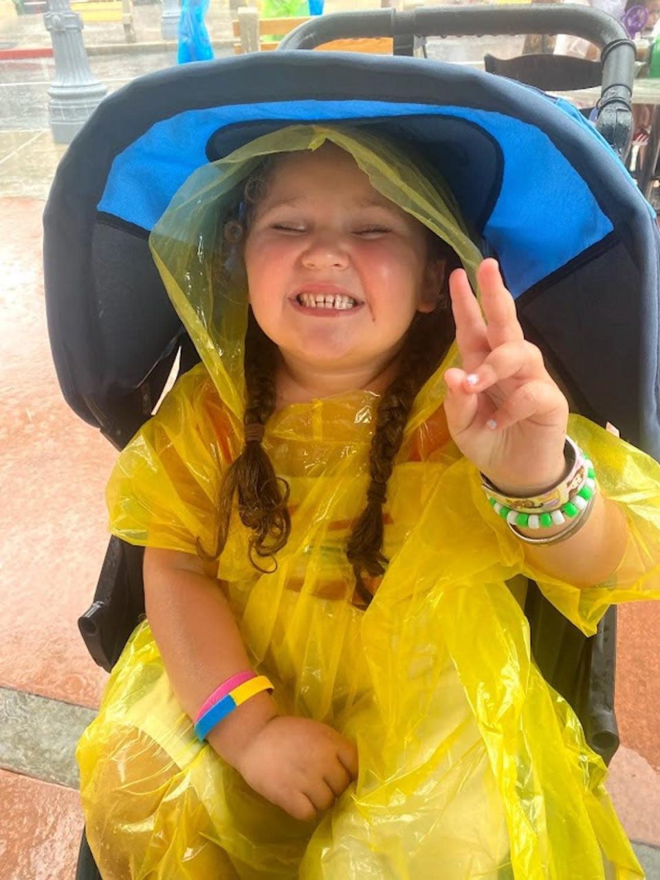 Kathryn Finkelstein&#39;s daughter, Ella, in a rain poncho at Disney.