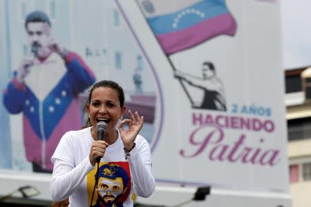 FILE PHOTO: Venezuelan opposition leader Maria Corina Machado speaks in front of a billboard with a picture of Venezuela's President Nicolas Maduro during a rally against him in Caracas, Venezuela April 24, 2017. The billboard reads, "2 years making homeland". REUTERS/Marco Bello/File Photo