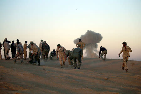 Shi'ite fighters take cover from a car bomb attack during a battle with Islamic State militants at the airport of Tal Afar west of Mosul, Iraq November 18, 2016. REUTERS/Thaier Al-Sudani