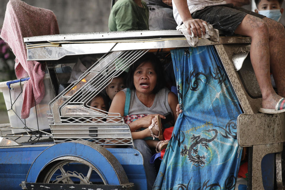 In this Sunday, Jan. 12, 2020, photo, residents evacuate as Taal Volcano erupts, in Tagaytay, Cavite province, outside Manila, Philippines. A tiny volcano near the Philippine capital that draws many tourists for its picturesque setting in a lake belched steam, ash and rocks in a huge plume Sunday, prompting thousands of residents to flee and officials to temporarily suspend flights. (AP Photo/Aaron Favila)