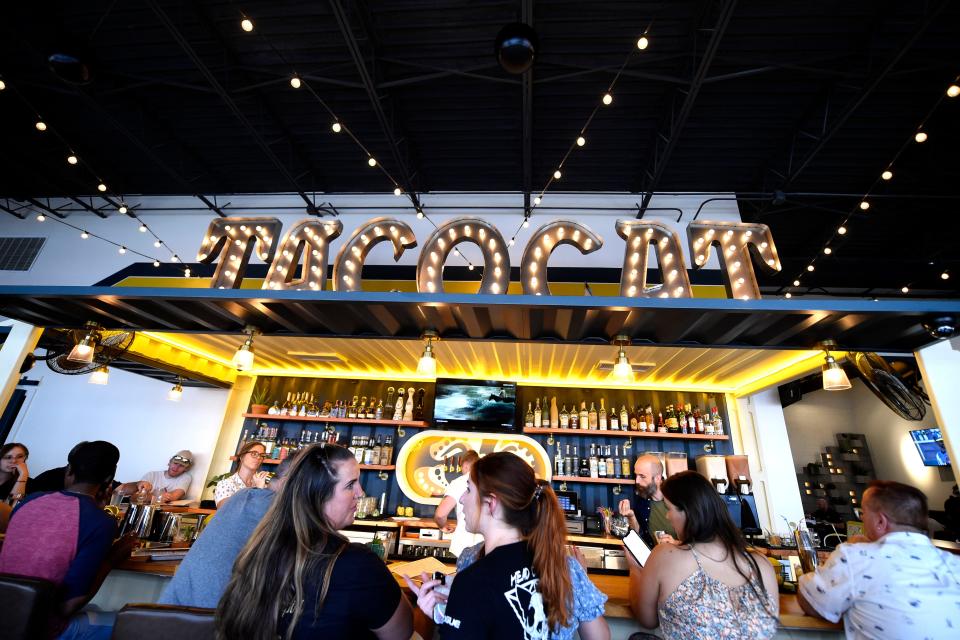 People sit at the bar during the Tacocat opening on July 6.