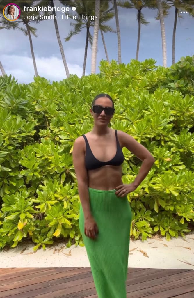 Frankie Bridge wearing a black bikini top and green skirt