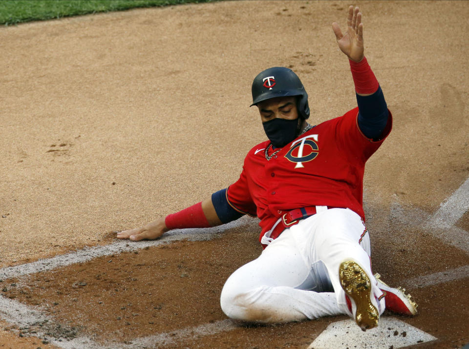 Minnesota Twins' Nelson Cruz scores on a two-run double by Eddie Rosario off Cleveland Indians' pitcher Mike Clevinger in the first inning of a baseball game Friday, July 31, 2020, in Minneapolis. (AP Photo/Jim Mone)