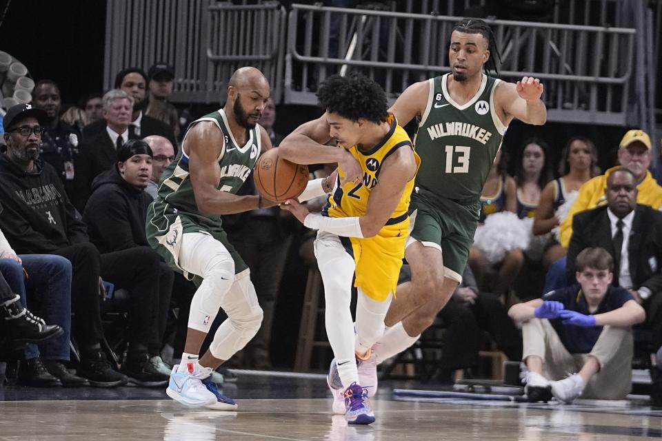 Indiana Pacers' Andrew Nembhard (2) has the ball taken away by Milwaukee Bucks' Jevon Carter (5) and Jordan Nwora (13) looks on during the second half of an NBA basketball game, Friday, Jan. 27, 2023, in Indianapolis. (AP Photo/Darron Cummings)