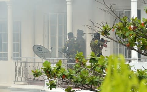 Sri Lankan Special Task Force (STF) personnel are pictured outside a house during a raid - Credit: ISHARA S. KODIKARA/AFP