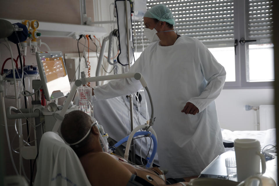 A member of the medical staff tends to a patient affected by the COVID-19 virus in the ICU unit at the Charles Nicolle public hospital, Thursday, April 15, 2021 in Rouen, France. A renewed crush of COVID-19 cases is again forcing intensive care units across France to grapple with the macabre mathematics of how to make space for thousands of critically ill patients (AP Photo/Christophe Ena)