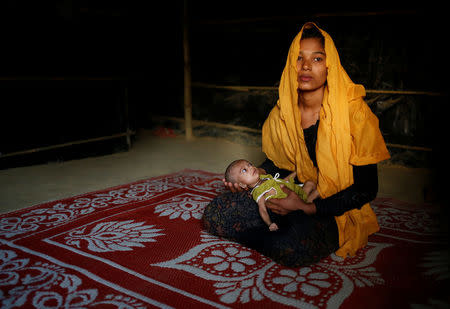 Sanwara Begum, 20, poses for a photograph with her 25-day-old daughter Aasma inside their shelter in Kutupalang unregistered refugee camp in Cox’s Bazar, Bangladesh, February 9, 2017. REUTERS/Mohammad Ponir Hossain