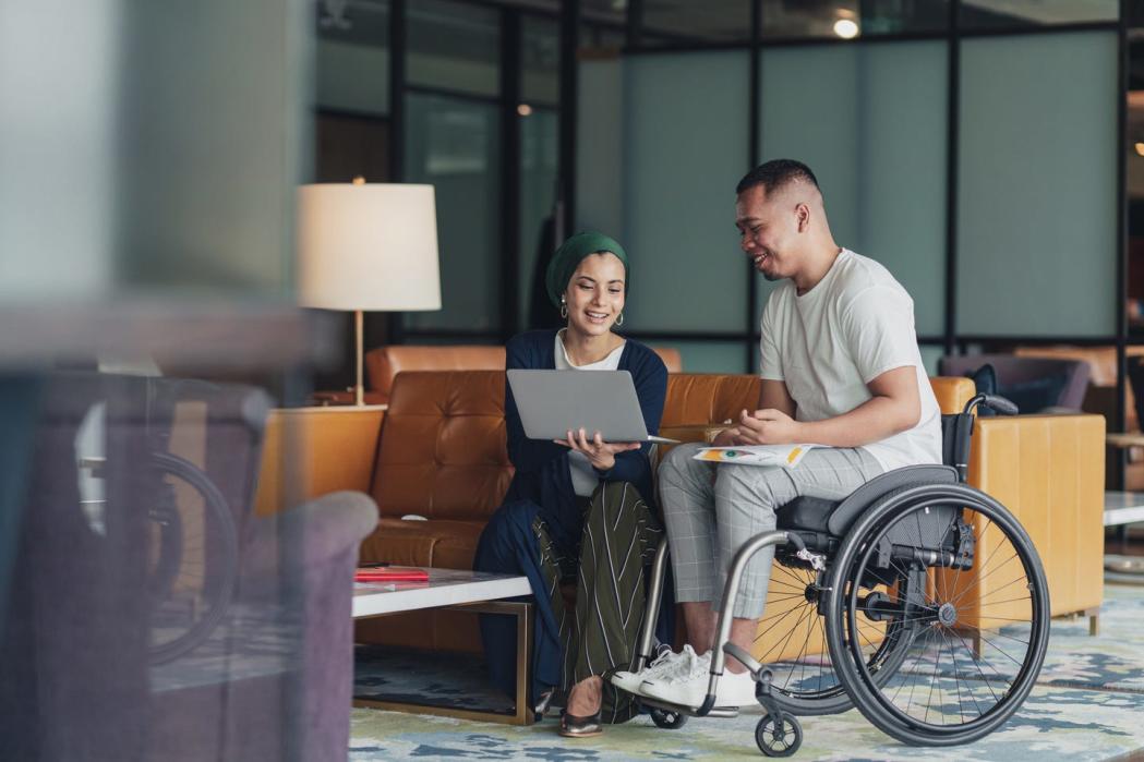 teamwork in business a female leader sharing insights with a disabled co worker