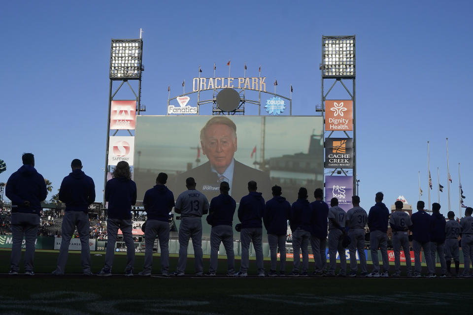 A tribute to broadcaster Vin Scully is shown on a video board at Oracle Park above Los Angeles Dodgers players and coaches before a baseball game between the San Francisco Giants and the Dodgers in San Francisco, Wednesday, Aug. 3, 2022. (AP Photo/Jeff Chiu)