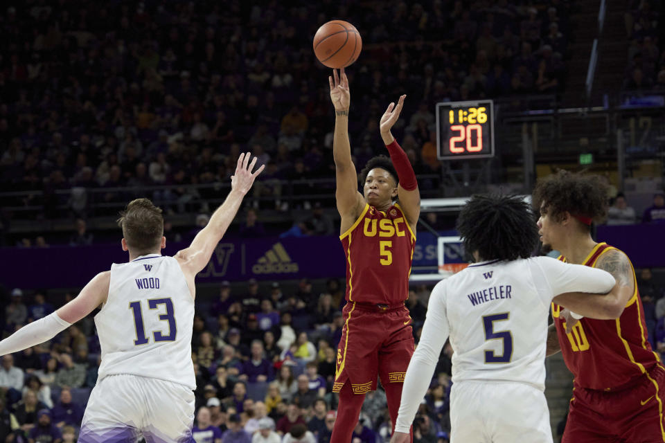 Southern California guard Boogie Ellis (5) shots as Washington forward Moses Wood (13) defends during the second half an NCAA college basketball game, Saturday, March 2, 2024, in Seattle. (AP Photo/John Froschauer)