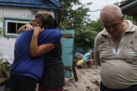 Nina Bilyk, left, is embraced by her friend, Olga Gurina, as she mourns the loss of her partner, Ivan Fartukh, along with his cousin, Andrii Fartukh, right, at their home Saturday, Aug. 13, 2022, where he was killed in a Russian rocket attack last night in Kramatorsk, Donetsk region, eastern Ukraine. The strike killed three people and wounded 13 others, according to the mayor. The attack came less than a day after 11 other rockets were fired at the city. (AP Photo/David Goldman)