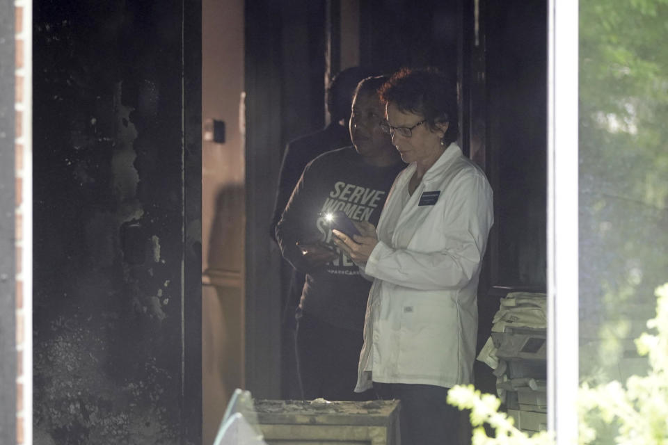 CompassCare employees survey the damage of an early morning firebombing at their anti-abortion center in Amherst, N.Y., on Tuesday, June 7, 2022. (Mark Mulville/The Buffalo News via AP)