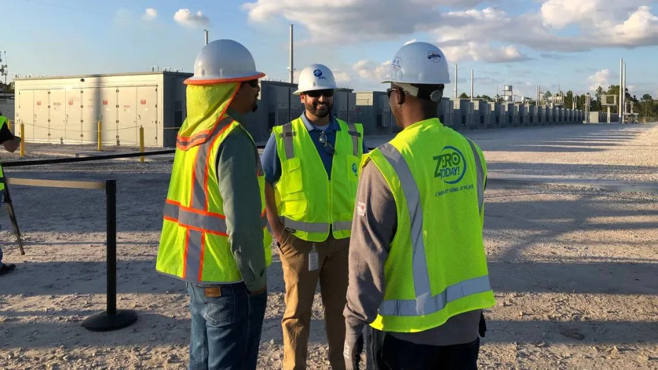 12/13/2021--FPL workers stand next to a solar-powered battery in Parrish that occupies space to equivalent to about 30 football fields.