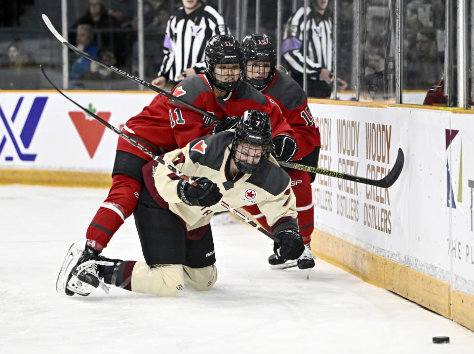 Ottawa's Akane Shiga (11) makes contact with Montreal's Laura Stacey (7) as they chase the puck behind Ottawa's net during the first period of a PWHL hockey game in Ottawa, Ontario, Tuesday, Jan. 2, 2024. (Justin Tang/The Canadian Press via AP)