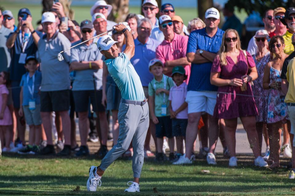 Fans watch Eric Cole hit an approach shot from the 10th fairway during the final round of the Honda Classic this past February.