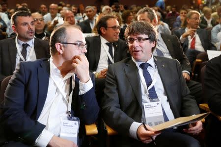 Catalan President Carles Puigdemont (R) sits next to Catalan Government Presidency Councillor Jordi Turull as they attend the Catalan European Democratic Party (PDeCAT) extraordinary national council meeting in Barcelona, Spain October 18, 2017. REUTERS/Gonzalo Fuentes