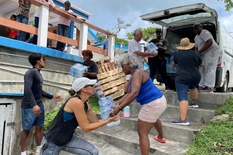 People load essential supplies for residents of Carriacou Island, which was ‘flattened’ in half an hour by Beryl on Monday (Reuters)