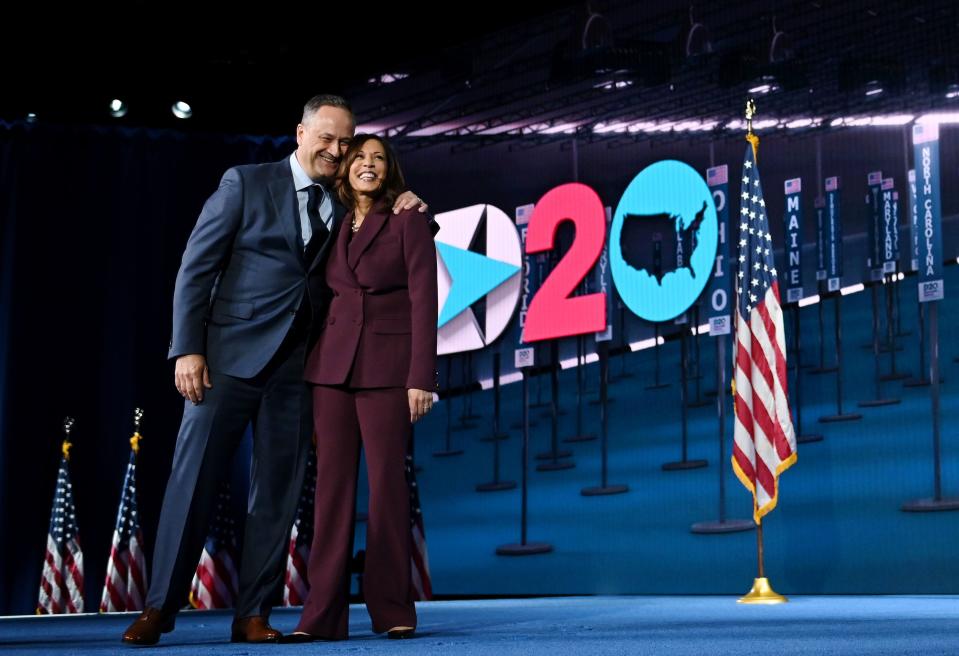 Democratic vice presidential nominee Kamala Harris and her husband Douglas Emhoff stand on stage at the end of the third day of the Democratic National Convention.