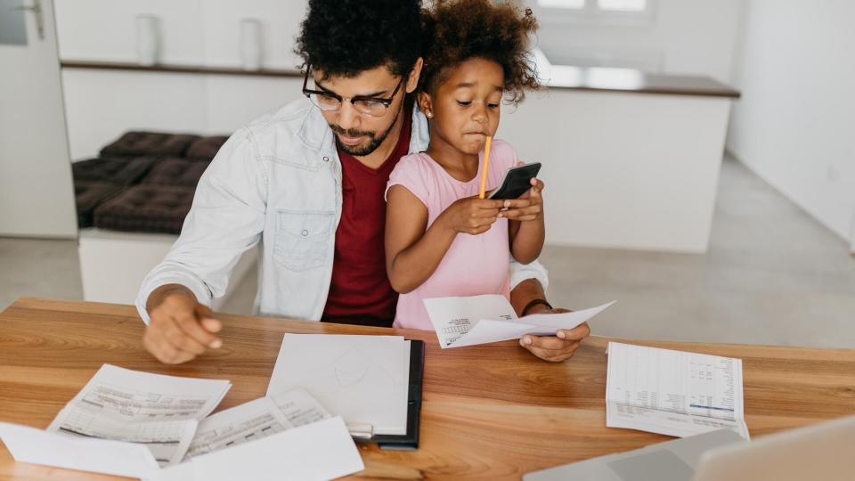 Father and daughter at apartment, domestic room, crowded with bills to pay.