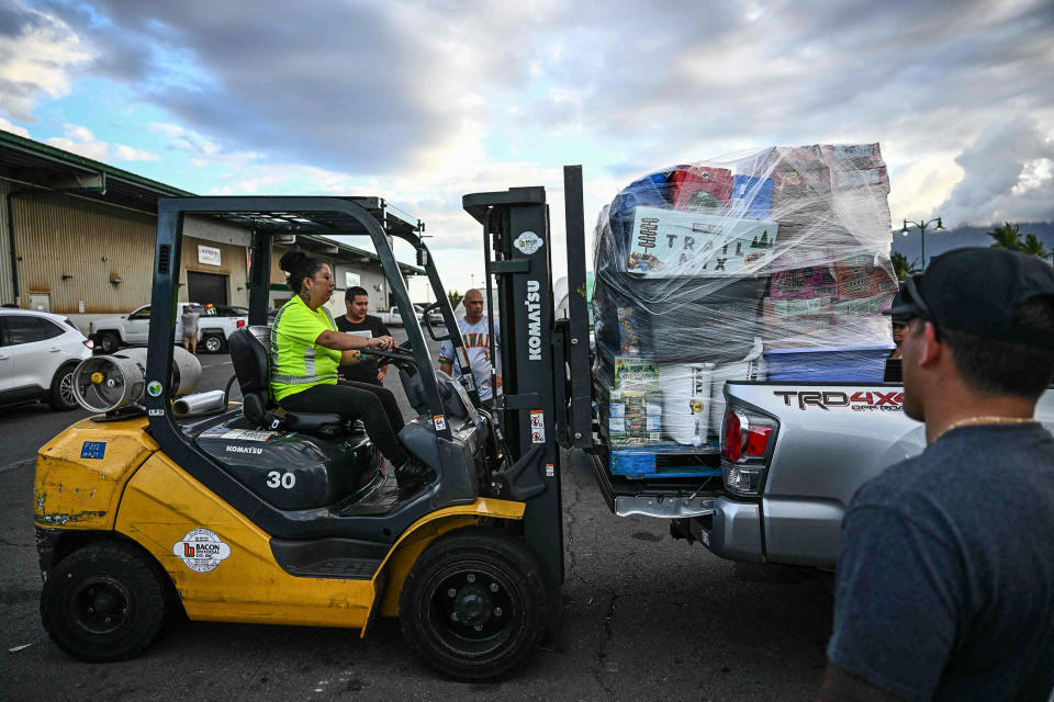 Image: A forklift loads a pallet of supplies and aid donations flown in from the Hawaiian island of Kauai into a pickup truck at the Kahului airport cargo terminal in the aftermath Maui wildfires in Kahului, Hawaii on Aug. 13, 2023.  (Patrick T. Fallon / AFP - Getty Images)