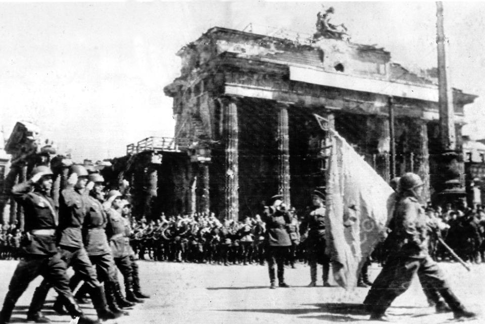 FILE - Soviet troops march past the Brandenburg Gate in Berlin, May 20, 1945, while carrying a victory banner that was raised over the defeated German capitol at the end of World War II. On Friday, May 10, 2024, , The Associated Press reported on stories circulating online incorrectly claiming images show the Soviet Victory banner projected by hackers onto the east side of Brandenburg Gate in Berlin on Tuesday night, prior to annual festivities celebrating the defeat of Nazi Germany in 1945. (AP Photo)