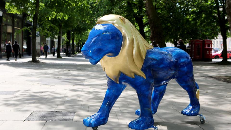 A blue lion sculpture with a gold mane on Cheltenham Promenade