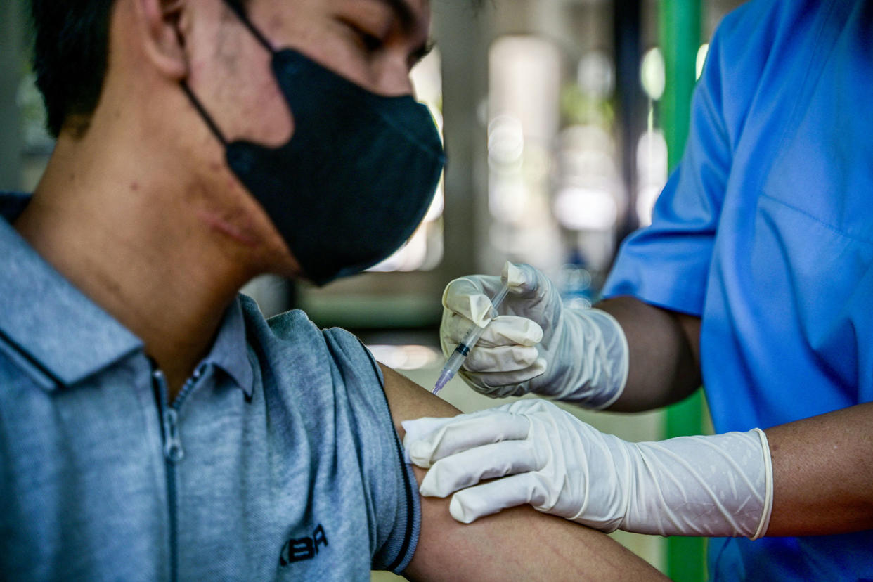 A health worker injects a man with a shot of the Inavac vaccine for Covid-19 at the Jakarta provincial health office on December 19, 2023. BAY ISMOYO/AFP via Getty Images